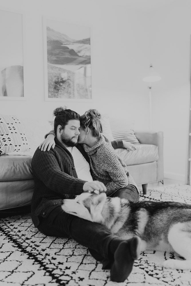 couple petting dog in home photoshoot