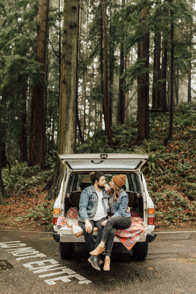 engagement photoshoot couple posing in jeep washington forest