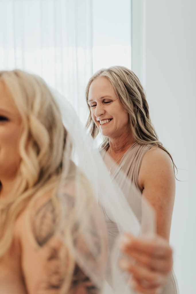 Mother helping daughter into wedding dress
