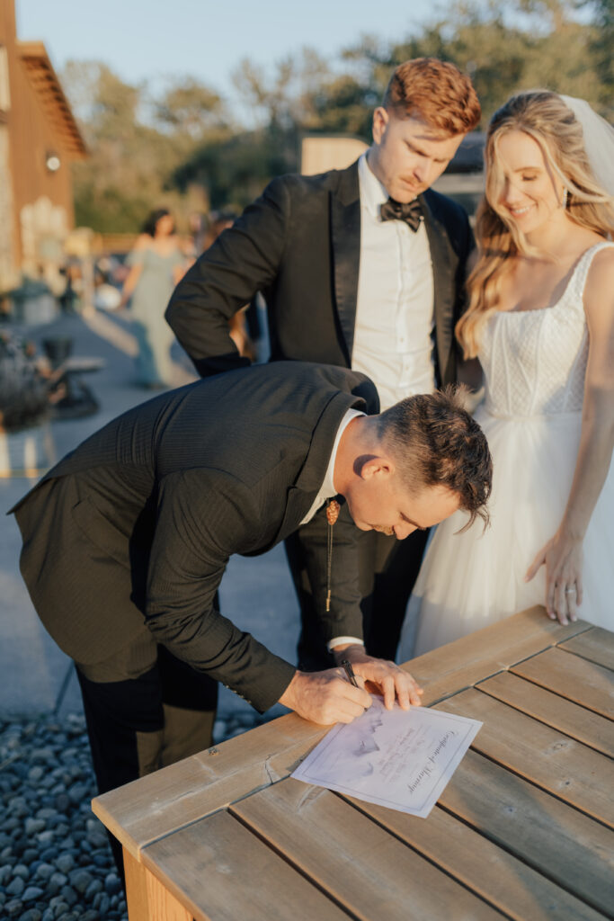bride and groom officiant signing marriage license